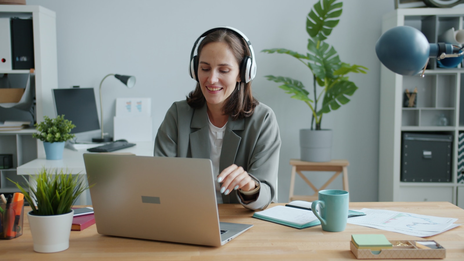 Woman working focused at her desk with headphones on — setting boundaries at work to protect her concentration